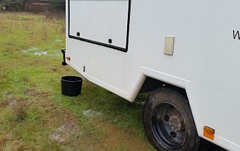 Eimer unter dem Wohnmobil, um Regenwasser aufzufangen.